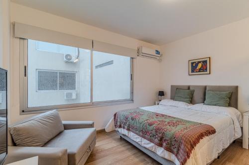 a bedroom with a bed and a large window at Hermoso Departamento en Palermo! in Buenos Aires
