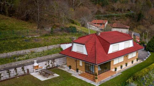 ein Haus mit einem roten Dach auf einem Hügel in der Unterkunft MIRADOR PIE DE LA SIERRA in Llanes