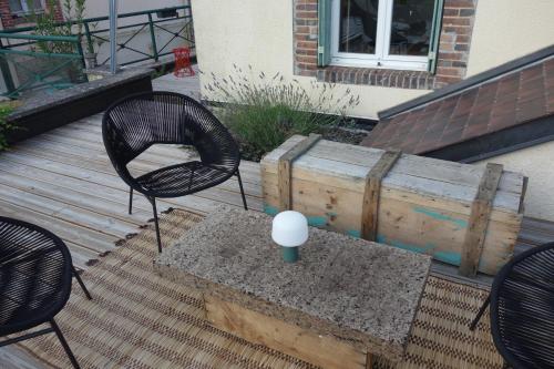 a patio with two chairs and a table with a candle on it at la maison haute in Toucy