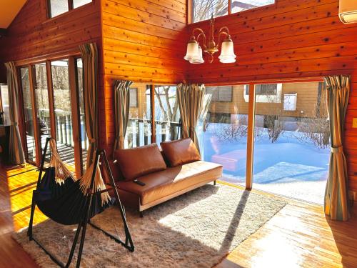 a living room with a couch and a hammock at ＨARUNA VILLA 浅間山麓、貸切コテージ、アクセス抜群 in Kita-karuizawa
