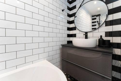 a bathroom with a sink and a mirror at Light bright & contemporary split-level apartment in Brighton & Hove