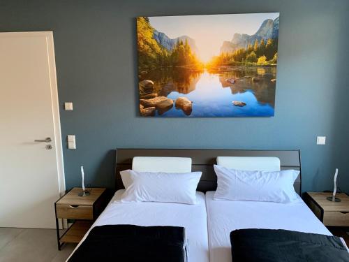 a bedroom with two beds and a painting on the wall at APPARTEMENT3 in Dahn