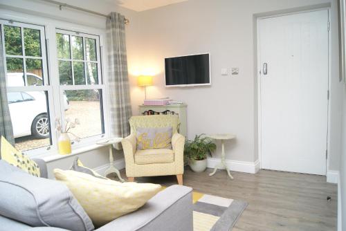 a living room with a couch and a chair at Secret Mersea Retreat - a stroll from the anchorage! in West Mersea