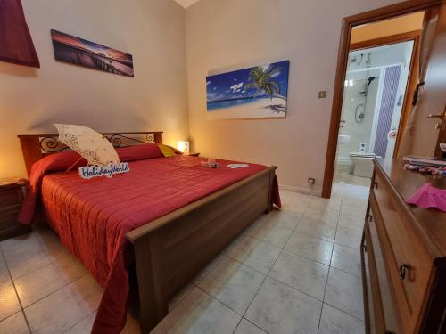 um quarto com uma cama com uma colcha vermelha em Il Paradiso di Rosalba by Holiday World em Ficarazzi