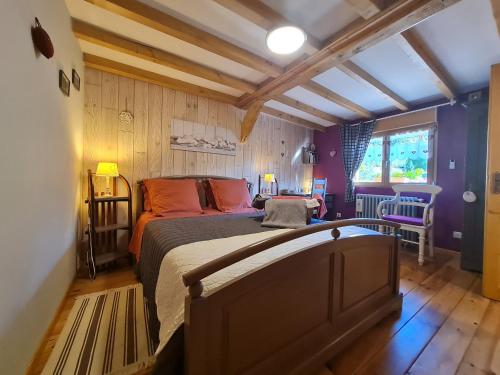 a bedroom with a large bed in a room with wooden floors at Chambre double confortable avec accès indépendant à Rochesson, près de Gérardmer - FR-1-589-575 in Rochesson