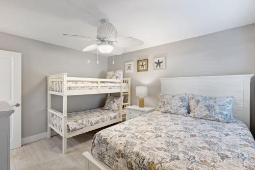 a bedroom with a bed and a chair in it at Loggerhead 261 in Sanibel