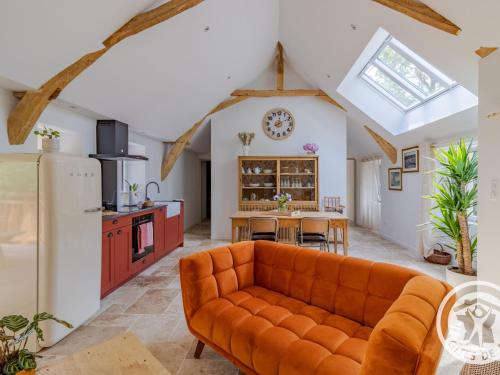 Il comprend une cuisine ouverte et un salon avec un canapé orange. dans l'établissement Maison de Vacances Rénovée sur l'Île Fluviale de Chalonnes, Terrasse, BBQ, Prêt de Vélos - FR-1-622-61, à Chalonnes-sur-Loire