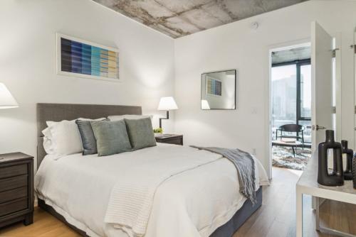 a white bedroom with a bed and a window at Contemporary City Living Apartments in Nashville in Nashville