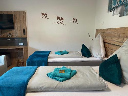 two beds in a room with blue sheets at FeWo Oldau's Nestchen in Oldau