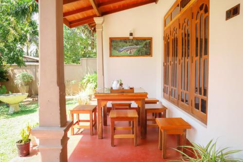 a patio with a wooden table and chairs at Punida villa in Matara