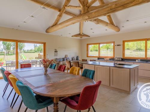 une cuisine et une salle à manger avec une table et des chaises en bois dans l'établissement Gîte familial avec piscine privée, proche d'Angers et du Zoo de La Flèche - FR-1-622-65, à Baugé