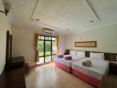 a bedroom with two beds and a window at Private Pool Villa Lot 872 - Fong Homestay in Kampong Alor Gajah