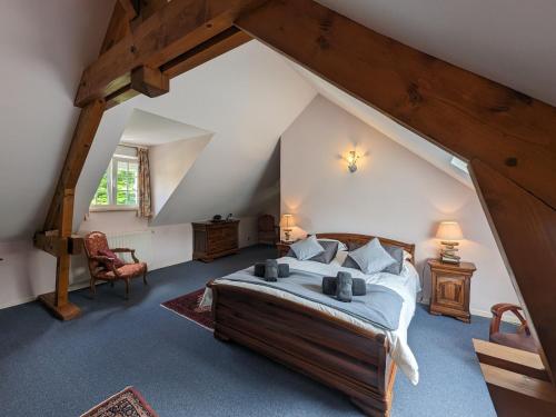 une chambre avec un grand lit dans un grenier dans l'établissement Maison Spacieuse en Village, Équipée et Confortable, avec Accès Rivière et Garage. - FR-1-611-93, à Louvemont