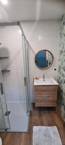 een badkamer met een douche, een wastafel en een spiegel bij Modern, spacious 2 bed riverfront apartment with pool for 4-6 people in Lamonzie-Saint-Martin