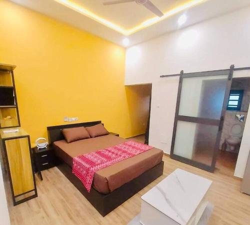 ein Schlafzimmer mit einem Bett und einer gelben Wand in der Unterkunft Les 9 Plurielles - Studio 3 KPALIME KOUMA KONDA 