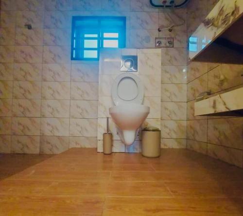 ein Bad mit einem weißen WC in einem Zimmer in der Unterkunft Les 9 Plurielles - Studio 3 KPALIME KOUMA KONDA 