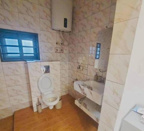 a bathroom with a toilet and a sink and a tub at Les 9 Plurielles - Studio 3 KPALIME KOUMA KONDA 