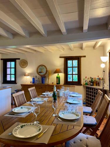 - une grande table en bois avec des assiettes et des verres à vin dans l'établissement Superbe Maison normande - Piscine, à Saint-Pierre-des-Ifs