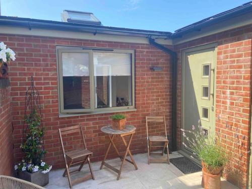 a patio with two chairs and a table and a window at The Hideaway in Emsworth