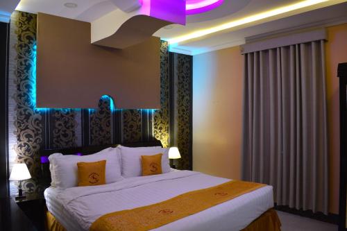 1 dormitorio con 1 cama grande y techo púrpura en منتجع شاطئ العرب الرايس, en Rayyis
