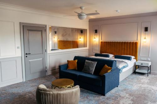 1 dormitorio con 1 cama y 1 sofá azul en The Hotel Fitzgerald en Praga