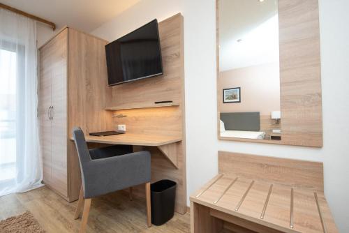 a room with a desk and a tv on a wall at Neckarperle in Edingen-Neckarhausen