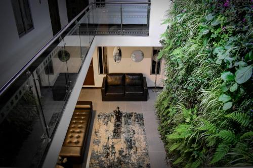 a living room with a couch and a wall of plants at Hotel DC Feria in Bogotá