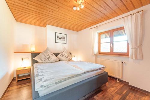 a bedroom with a large bed with a wooden ceiling at Bergblick-Ferienwohnungen in Bad Hindelang