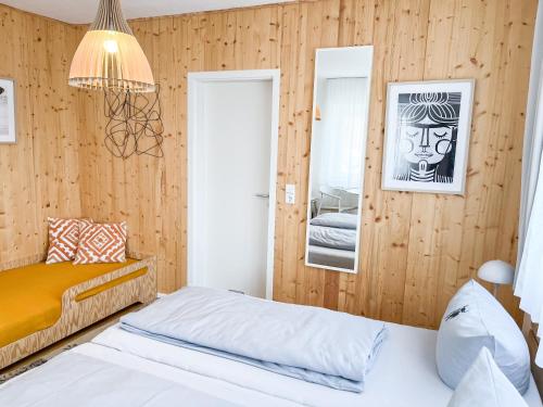Schlafzimmer mit holzgetäfelten Wänden und einem Bett in der Unterkunft Hacienda Hotel in Friedrichshafen