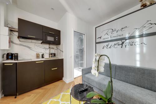 ein Wohnzimmer mit einem Sofa und einer Küche in der Unterkunft 213 Suite Givenchy - Superb apartment in Paris in Paris