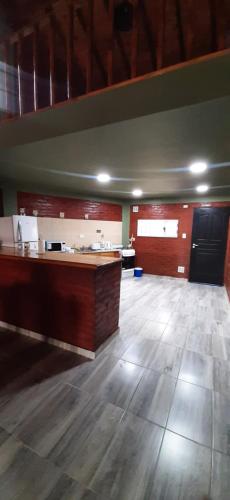 a large room with wooden floors and a large counter at ALQUILER TEMPORARIO EN TRELEW in Trelew