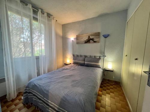 une chambre avec un lit et deux fenêtres dans l'établissement Noug, à Valras-Plage