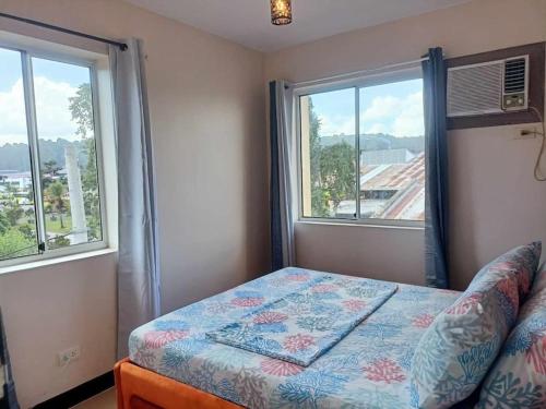 - une chambre avec un lit et 2 fenêtres dans l'établissement Tim's 2BR / 1T&Bath 8 Spatial Condo Maa Davao City, à Davao