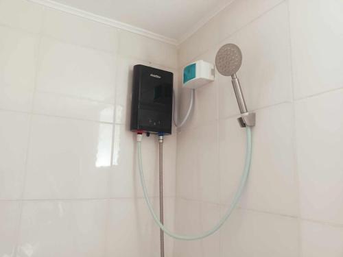 La salle de bains est pourvue d'un pommeau de douche et d'un sèche-cheveux. dans l'établissement Tim's 2BR / 1T&Bath 8 Spatial Condo Maa Davao City, à Davao