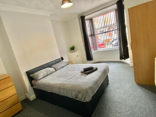ein Schlafzimmer mit einem Bett und einem großen Fenster in der Unterkunft Brooklyn Place by SG Property Group in Crewe
