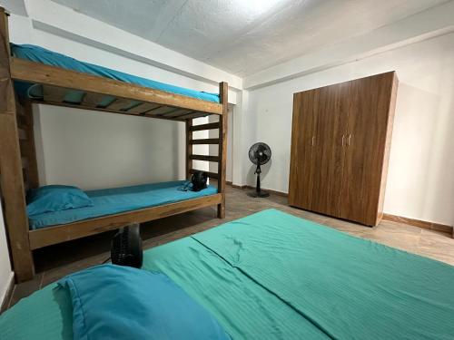 RokaDura Hostel في سانتا مارتا: غرفة نوم بسريرين بطابقين وخزانة