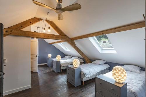 a attic bedroom with two beds and a ceiling fan at Superbe villa familiale - 1408 in Esterre