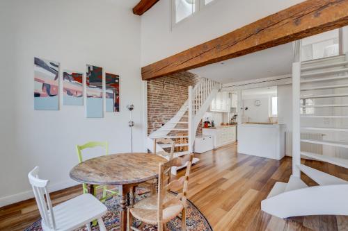 une cuisine et un salon avec une table et des chaises dans l'établissement Laganne by Yumē, à Toulouse