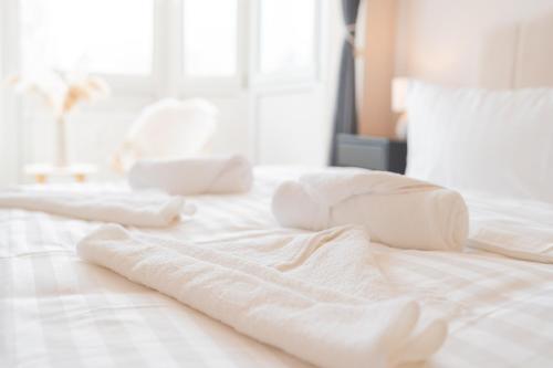 a white bed with two white towels on it at Dein Ruhepol an der Nordseeküste mit Sauna in Cappel-Neufeld