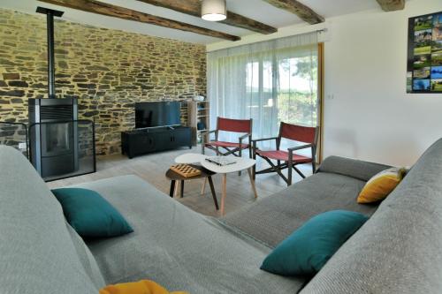 un salon avec un canapé et une cheminée dans l'établissement Ar Voudenn, à Roz-Landrieux