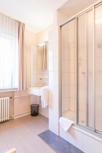 a bathroom with a shower and a sink at Hotel Elisabetha Garni in Hannover