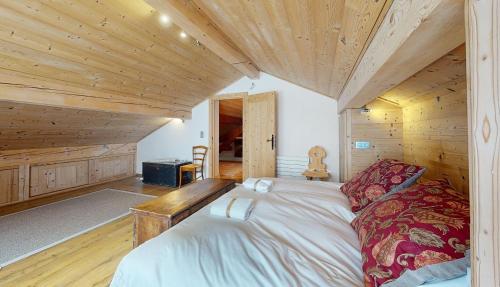 a large bed in a room with wooden walls at Chalet La Grande Ourse Meribel - superior apartment in Les Allues