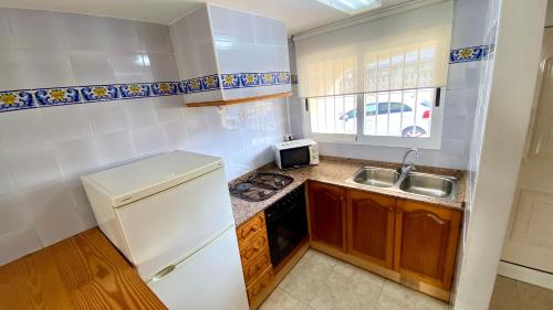 a kitchen with a white refrigerator and a sink at Apartamento Esmeralda VyB in Denia