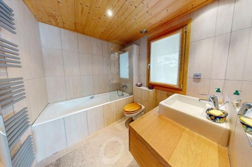 a bathroom with a tub and a toilet and a sink at Chalet La Grande Ourse Meribel - superior apartment in Les Allues