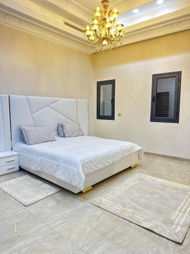 a bedroom with a large bed and a chandelier at Luxury Villa, Central Ac, Bbq, Ideal For Events in Rejiche