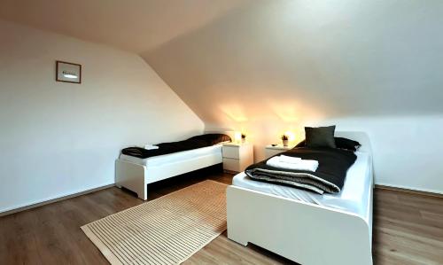 - une chambre mansardée avec 2 lits et un tapis dans l'établissement Exklusive Wohnung für Monteure in Bochum, à Bochum