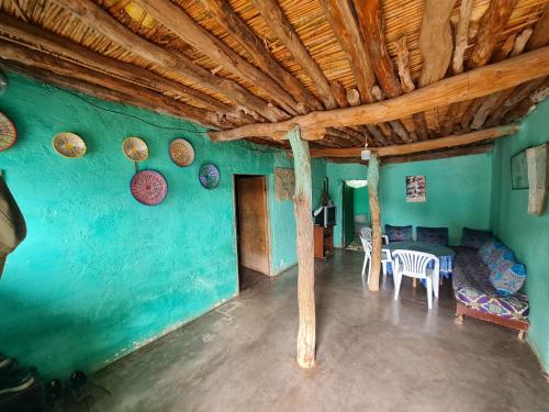 a room with a green wall with a table and chairs at Gite Ain Bechar in Taza
