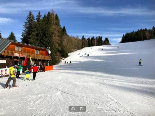 a group of people skiing down a snow covered slope at Chaty a horský hotel Kožiar in Žiar
