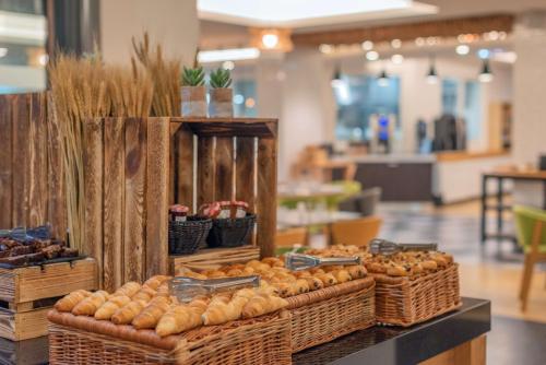 a display with baskets of bread and other foods at DoubleTree by Hilton Paris Bougival in Bougival