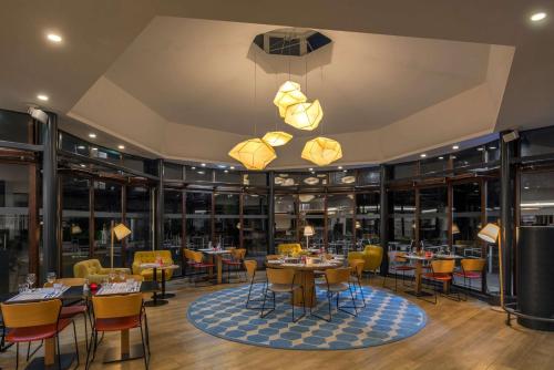 a restaurant with tables and chairs and lights at DoubleTree by Hilton Paris Bougival in Bougival